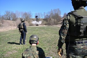 Instruktor i słuchacze podczas świczeń na poligonie 